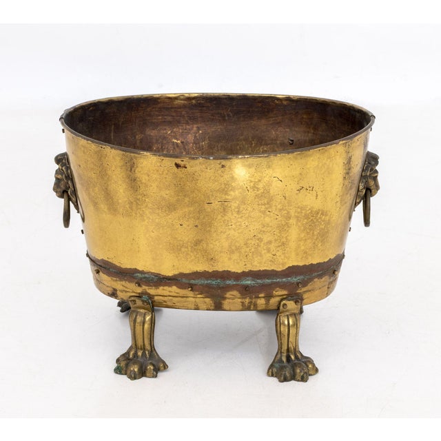 Victorian Lion's Masque Ring Handle Brass Jardiniere, 19th century, upon four lion's paw feet and marked "Made in /...