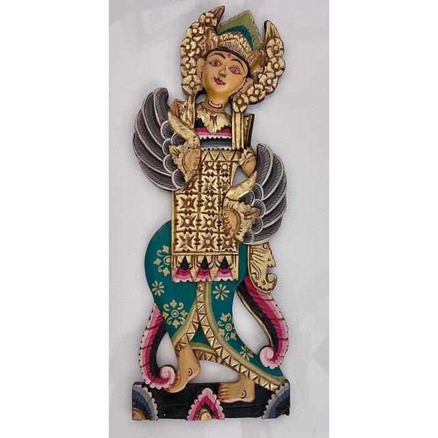A striking pair of hand-carved Balinese wood statues, each measuring approximately 26 inches high. These decorative...