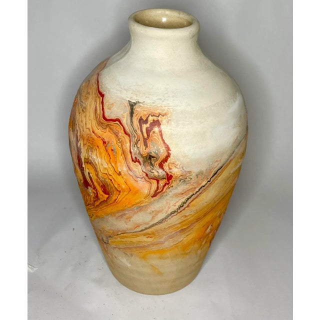 A great vintage piece of Nedmahi pottery with swirled orange, black, gray, white, and red. The piece is older with patina....