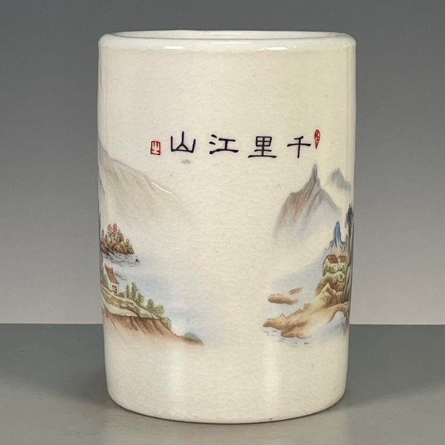 A charming Chinese porcelain brush pot (bitong). The cylindrical vessel features a creamy, all-over crackle glaze and is...