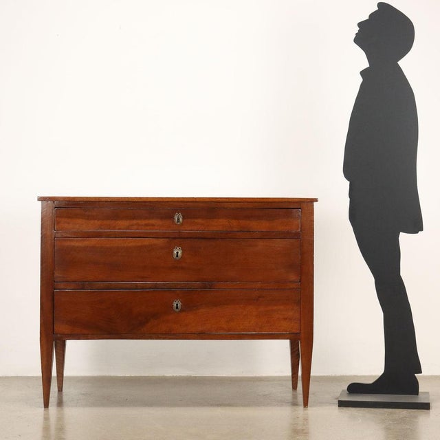 Antique Directoire chest of drawers, made of solid walnut, has uprights with truncated pyramid feet, three drawers on the...