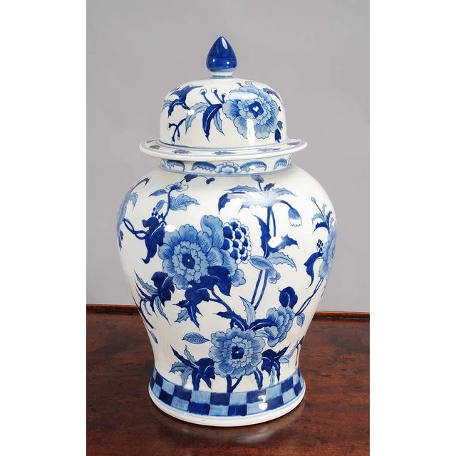 A pair of blue and white lidded temple jars with an overall floral pattern (more dense on the front and open on the...