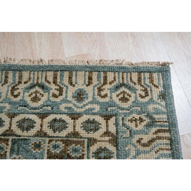 This gray wool rug features a traditional hand knotted pile weave construction. Produced in India, this floor covering...