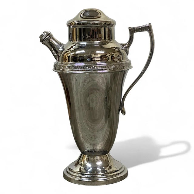 A Farberware chrome cocktail shaker. Art Deco style with with lid and screw down stopper. Signed "Farberware Brooklyn, NY"...