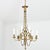 French, 19th century slender chandelier made of gilt bronze accented with dainty foliate and Neoclassical motifs in lieu...