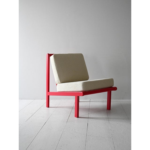 Vintage armchair with cherry red structure and new cushions reupholstered in light fabric. Essential and decisive lines....