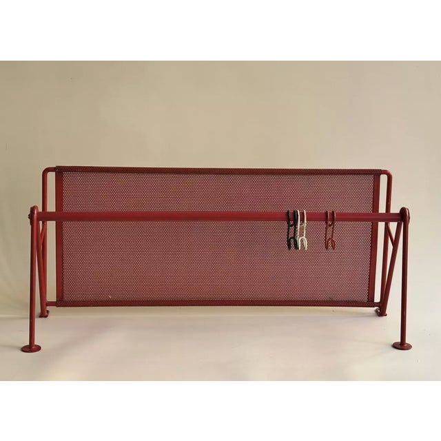 Red perforated metal shelf. In the style of Mathieu Matégot. Wall-mounted, it features a solid perforated metal shelf with...