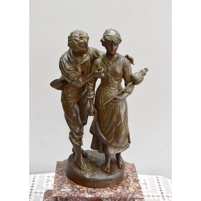 Red marble mantel clock topped with its Spelter sculpture signed Victor Rousseau (1865 - 1954). The sculpture represents a...