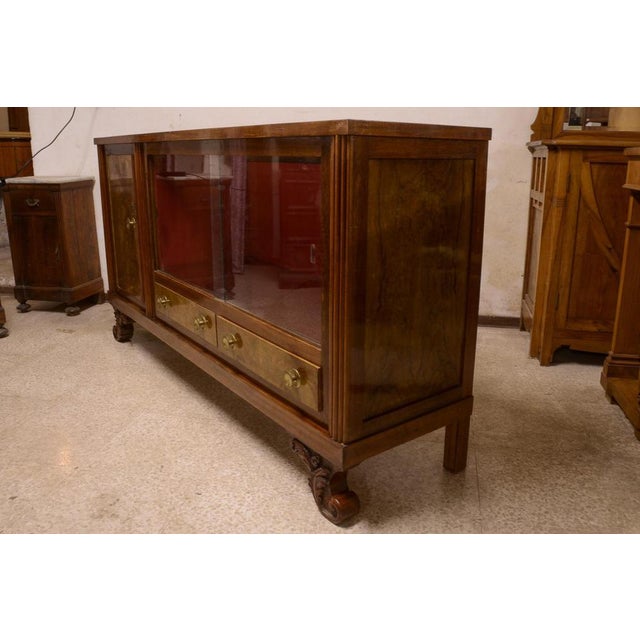Art deco sideboard in walnut briar with two sliding glasses, curly carved feet, a closed door and two drawers, complete...