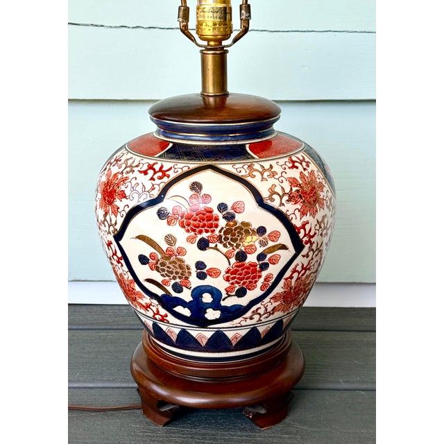 Vintage Frederick Cooper lamp featuring a hand‑decorated Imari‑style porcelain body, mounted on a carved wood base with...