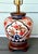 Vintage Frederick Cooper lamp featuring a hand‑decorated Imari‑style porcelain body, mounted on a carved wood base with...