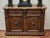 A representative piece of furniture made of solid walnut, decorated with rich hand carving. The front consists of a pair...