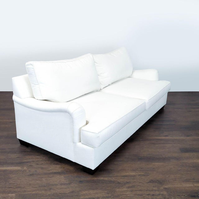 This Pottery Barn 3-seat sofa features a clean white upholstery, plush back and seat cushions, and gently curved arms for...