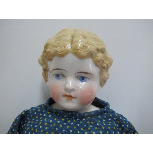 Mid to late 19th century, German Colonial girl doll. Porcelain head and shoulders with leather bodice/arms and legs, cloth...