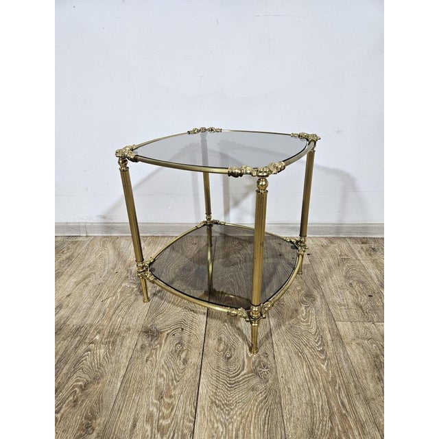 A stylish coffee table made in a glamorous aesthetic, mounted on a solid brass structure with rich decorations. The...