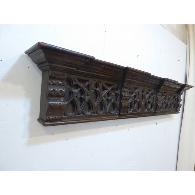 This carved oak shelf measures 9.5"H x 48.5"L x 6"D. It hangs from two bales on the back.