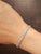 A modern platinum tennis bracelet featuring 44 natural emerald-cut white diamonds totaling 8.64 carats, graded G/H color...
