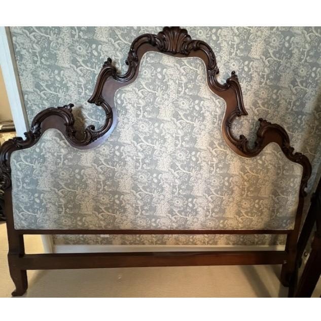 Grand and elegant French Provincial–style king headboard featuring an intricately carved wood frame and upholstered panel....