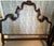 Grand and elegant French Provincial–style king headboard featuring an intricately carved wood frame and upholstered panel....