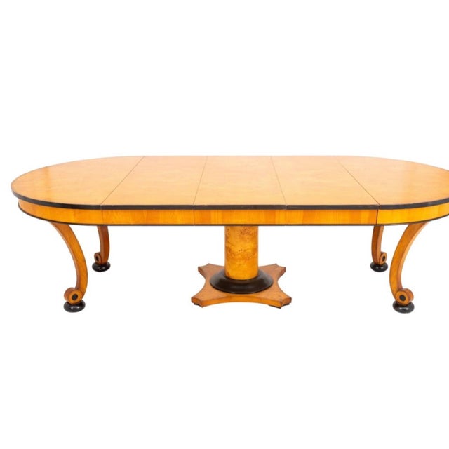 Biedermeier style birch and parcel ebonized extending circular dining table, the round top with extending mechanism and...