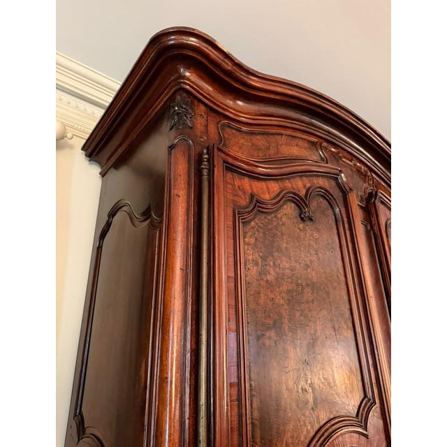 An exceptional 18th-century French Louis XV country walnut armoire, circa 1770, distinguished by richly figured burr elm...