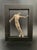 A Brutalist sculpture of a distressed nude figure nested in a display frame by Austin Productions. Estimated material:...