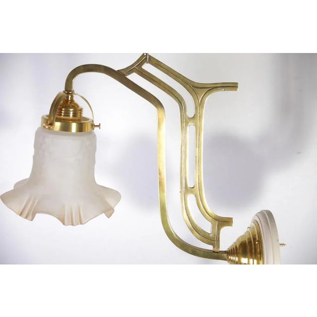 Excellent restored condition. New elektrification. Wall mounted pair of art nouveau lamps made of brass, sandblasted glass...