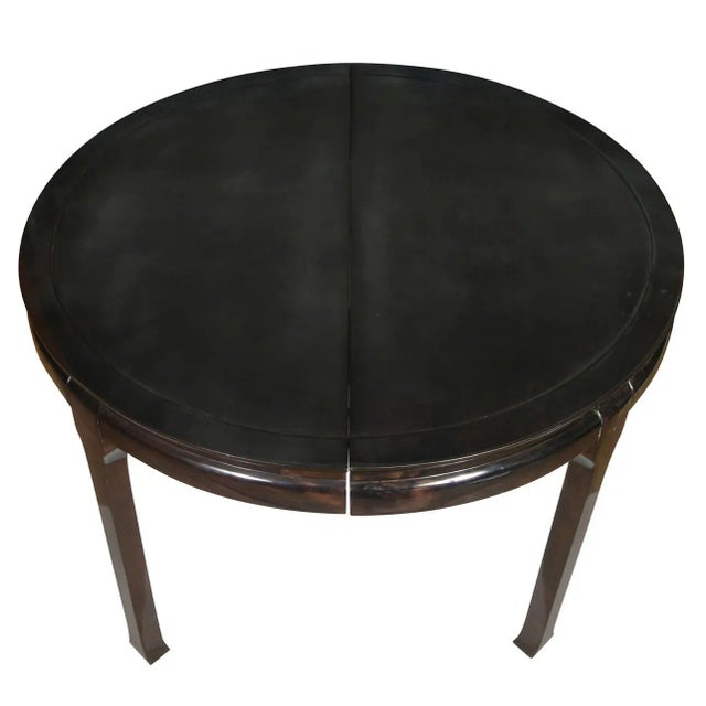 A Mid Century Asian style round dining table with one leaf, lacquered black - brown finish. Includes one leaf measures 20"