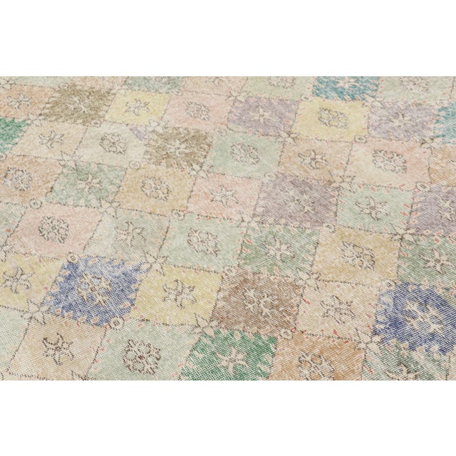 Hand-knotted in wool and originating from Turkey circa 1960 – 1970, this 6x6 vintage Zeki Müren square rug is a unique...