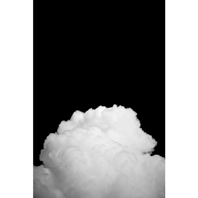 Black Clouds II captures a striking contrast between a billowing white cloud and a deep black background, emphasizing the...