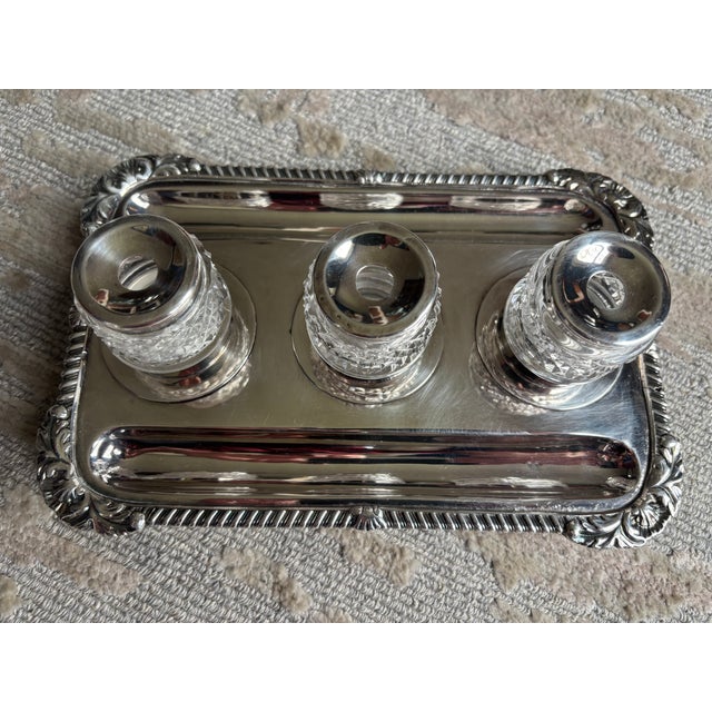 A Sheffield Silverplate Inkstand, mid to late 19th century with three cut glass inkwells capped in silver-plate that fit...