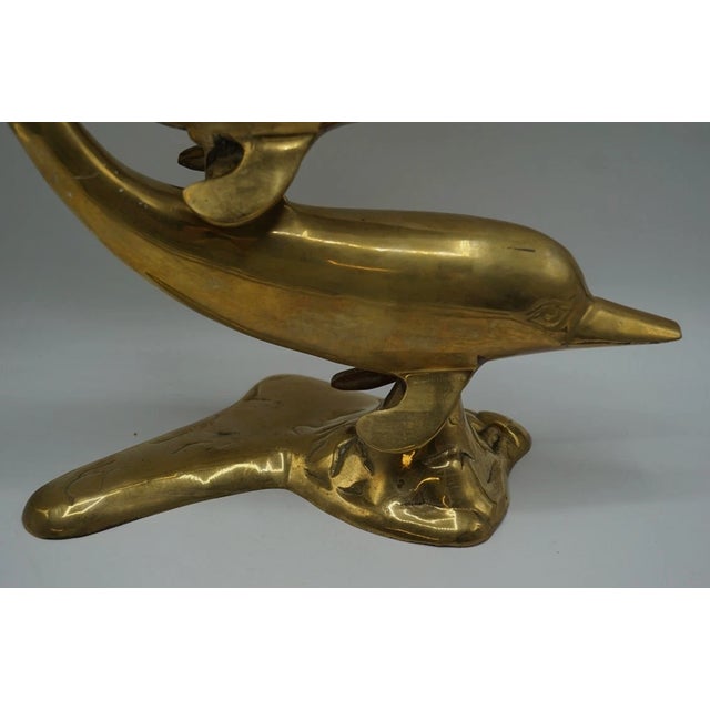 Beautiful vintage solid brass dolphin sculpture featuring two stylized dolphins in a dynamic leaping form. This sculptural...