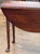A George III mahogany drop-leaf table with a shaped apron and slender turned legs. The top retains its original drop...
