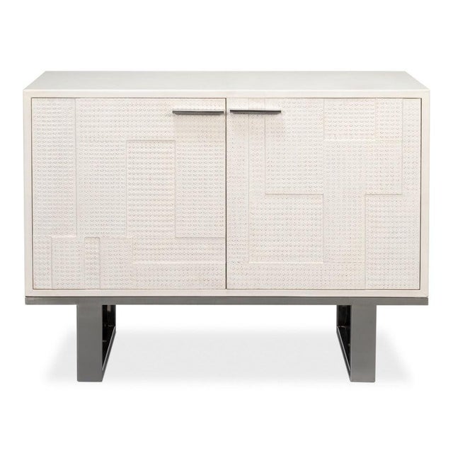 Embossed white leather textures the door fronts above a polished metal runner spanning the full width, giving the case a...