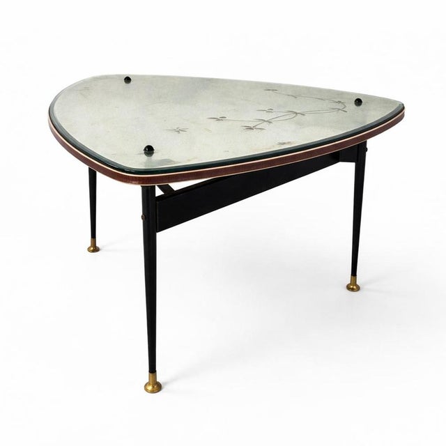 A striking Space Age–era mirrored coffee table, showcasing a beautifully shaped triangular top with softly rounded edges....