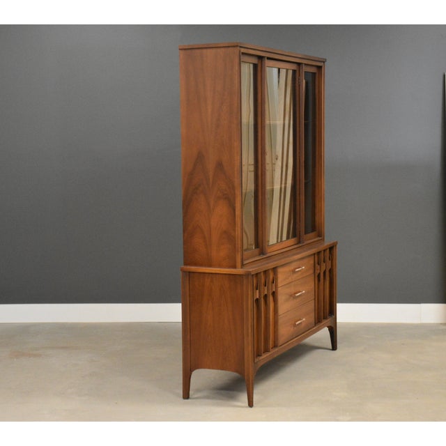 A mid century modern walnut three drawer, two door one piece credenza hutch made by Kent Coffey Perspecta. Professionally...