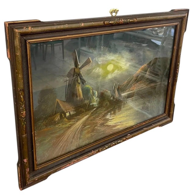 Vintage framed landscape painting depicting a moonlit waterside scene with a windmill, shoreline path, sailboats, and...