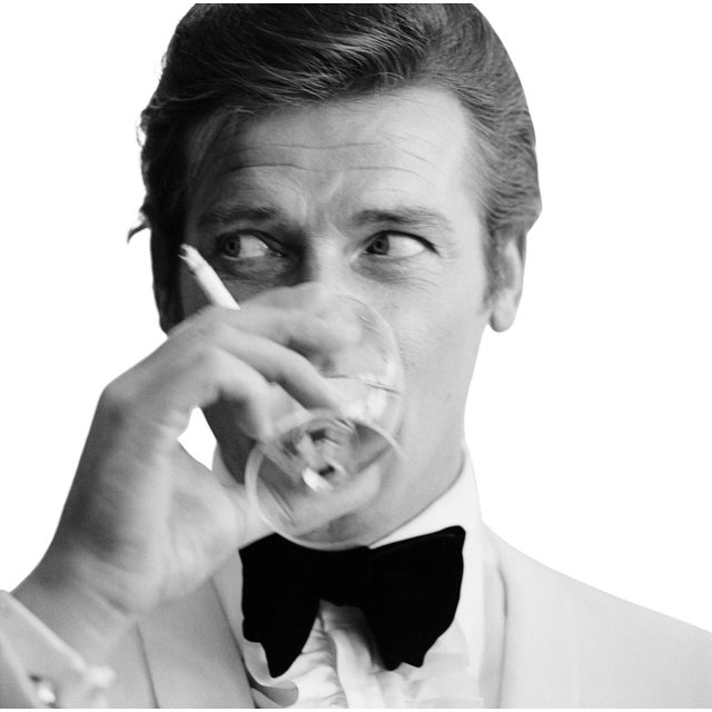 English actor Roger Moore, downs a Martini as James Bond, 17th July 1968. (Photo by Peter Ruck/BIPs/Getty Images) As an...