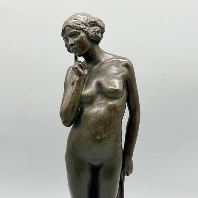 An art deco bronze sculpture of a nude woman in a pensive pose with a drape held behind her back. Signed k. Murray...