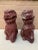 A wonderfully weathered pair of antique cast stone foo dogs, retaining their original red painted finish with beautifully...