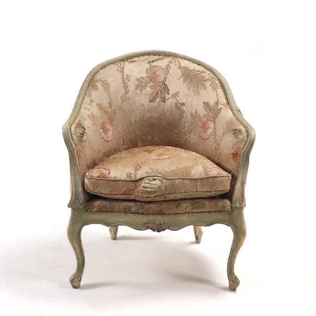 A pair of Italian rococo style painted and upholstered lounge chairs, 19th century. These tub style chairs having shapely...