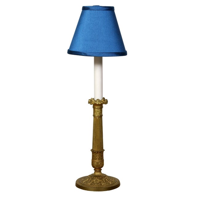 A pair of neoclassical gilt brass candlestick lamps. These gilt brass candle holders have been expertly transformed into...