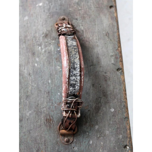 This vintage wooden toolbox showcases a weathered green finish, a leather-wrapped handle, and classic metal latches,...