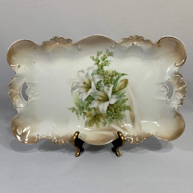A sweet Prussian rectangular dressing table plate featuring Easter Lillies; taupe clouding highlights circling around the...