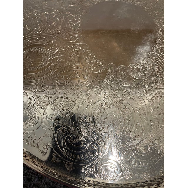 Vintage English silverplate round tray with pierced galley going around the tray. The tray is heavily embossed with...