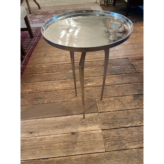 Eye catching sophisticated modern chrome end table having shiny slightly aged round top and elegant tripod tapered...