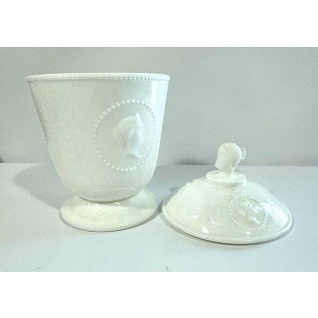 Wonderful milk glass covered jar by Atterbury, featuring cameo portraits, circa 1870. The top knop of the lid is a three-...