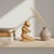 Hand-carved yellow jasper figure depicting a kneeling form with arms drawn inward, conveying a quiet, introspective...