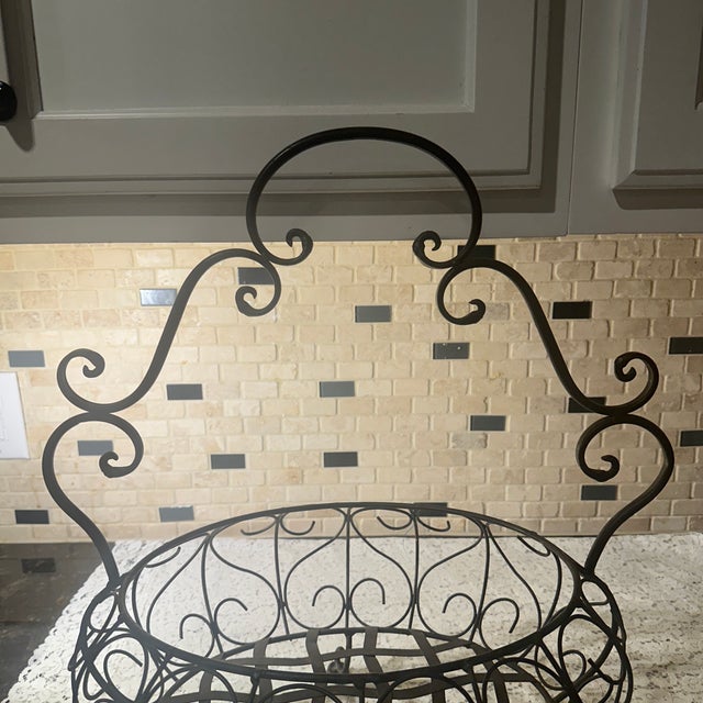 This basket is made out of/iron ornate scrollwork and handle, beautiful oval shape base to display, and it is footed....