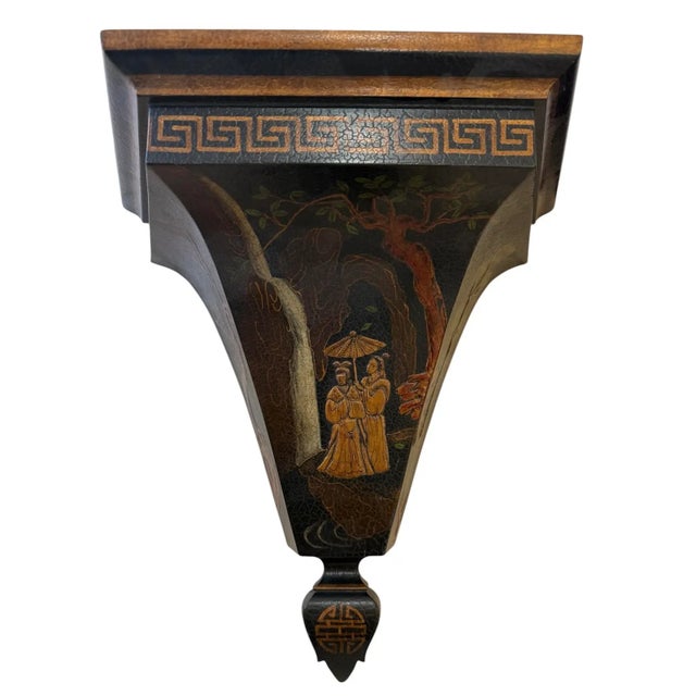 Pair of wood lacquered wall brackets. Black with raised sculptural design. Gilded accents, greek key banding. People in a...